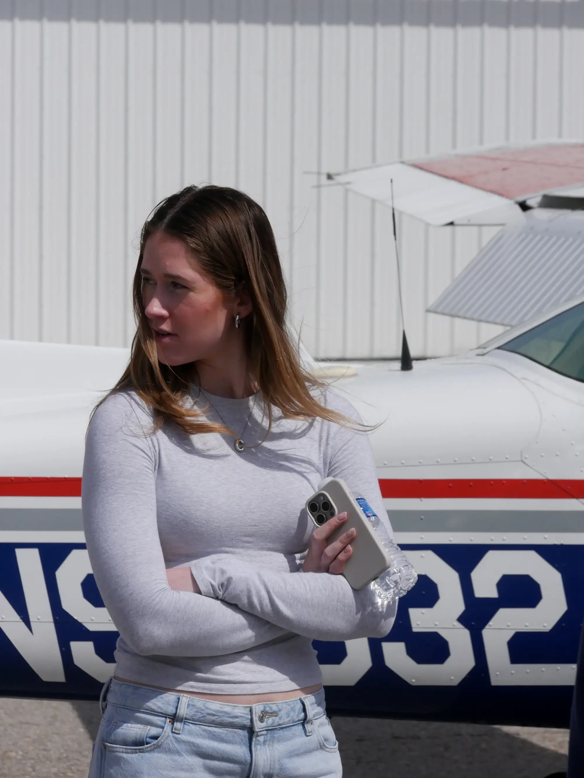 Woman in front of plane looking to the side