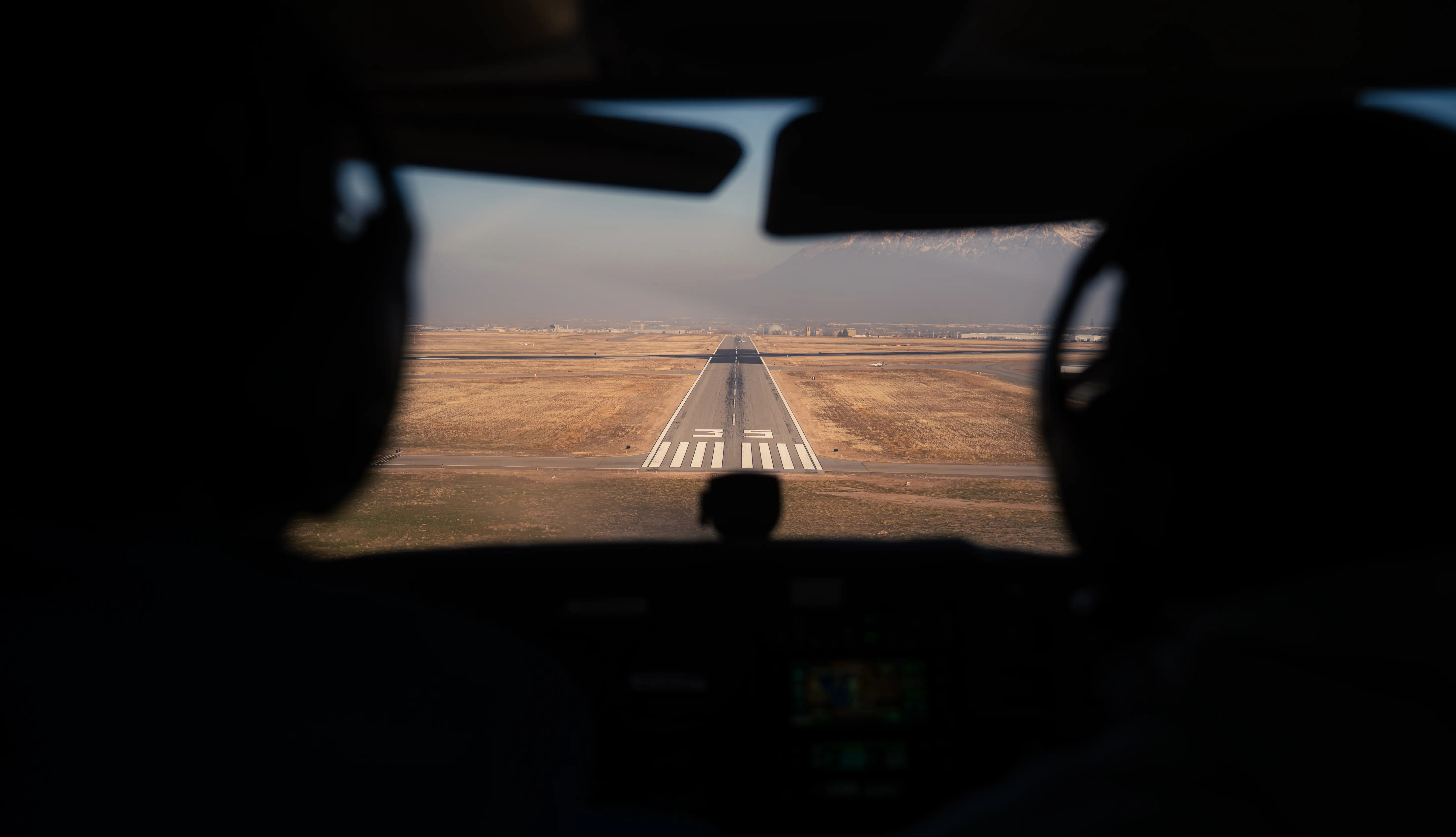 View of the back of two pilots in the cockpit while flying a plane
