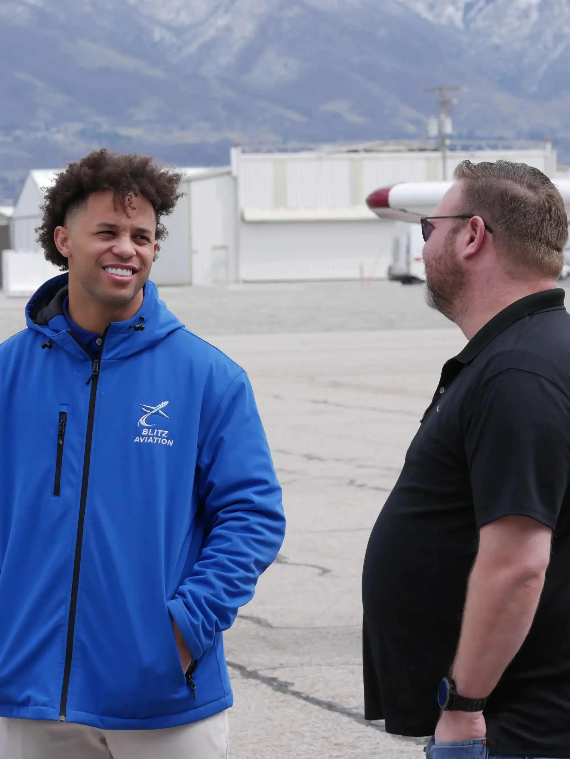 Two men chatting with mountains on the background