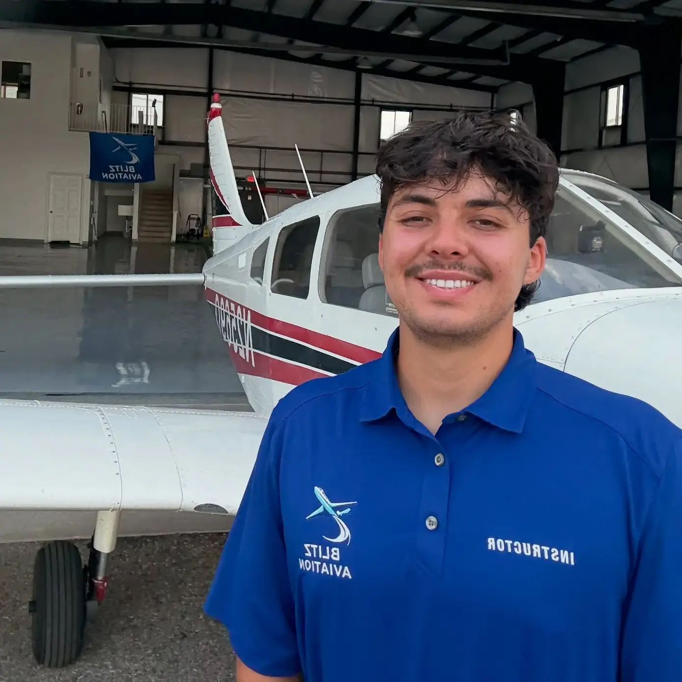 Woman with headset and sunglasses looking back at the camera while piloting an aircraft