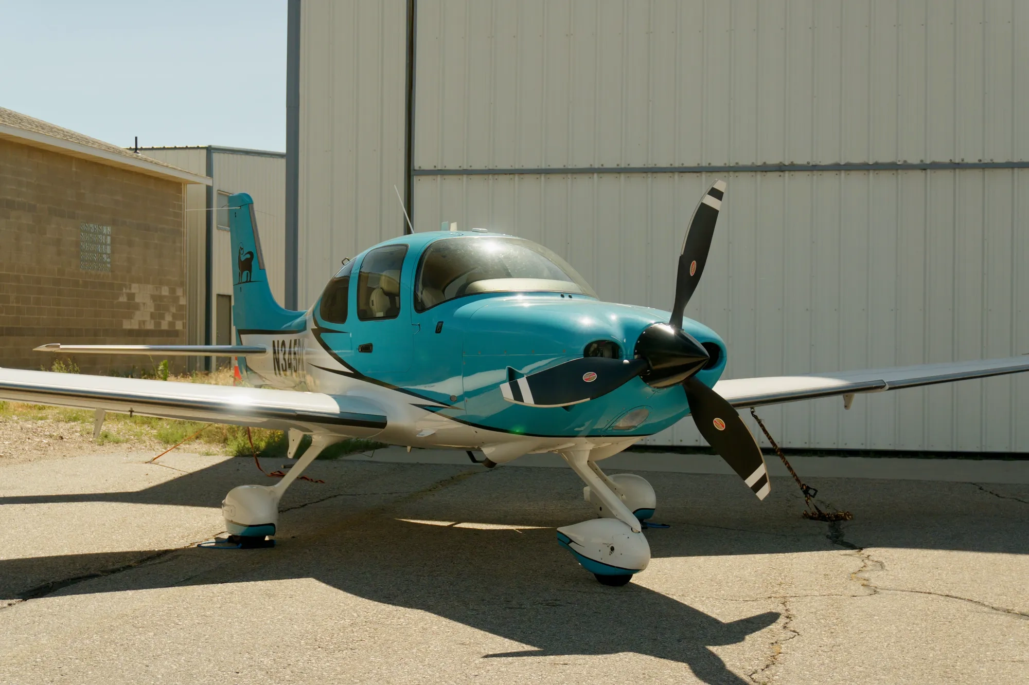 Cirrus SR22T training aircraft parked in front of a hangar at Blitz Aviation in Ogden, Utah
