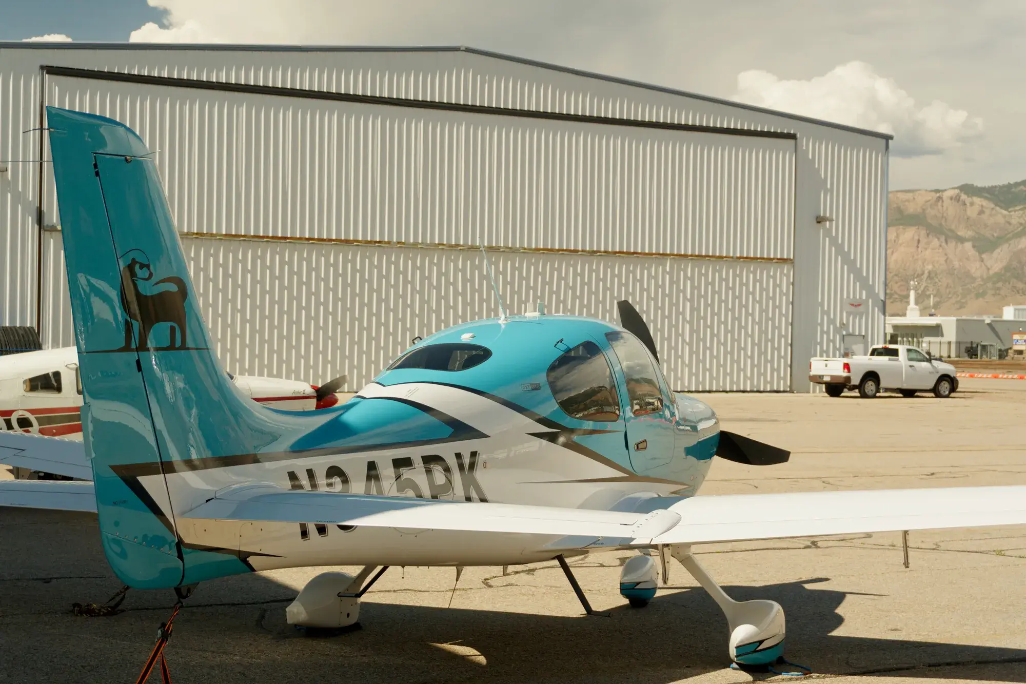 Tail and cabin of the Blitz Aviation Cirrus SR22T with the Wasatch mountains behind