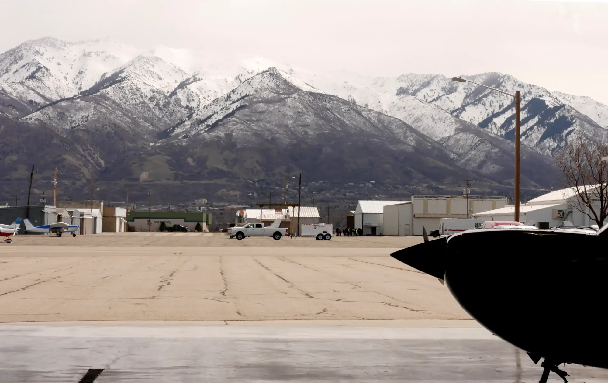 View from the ground of a hangar with mountains on the background