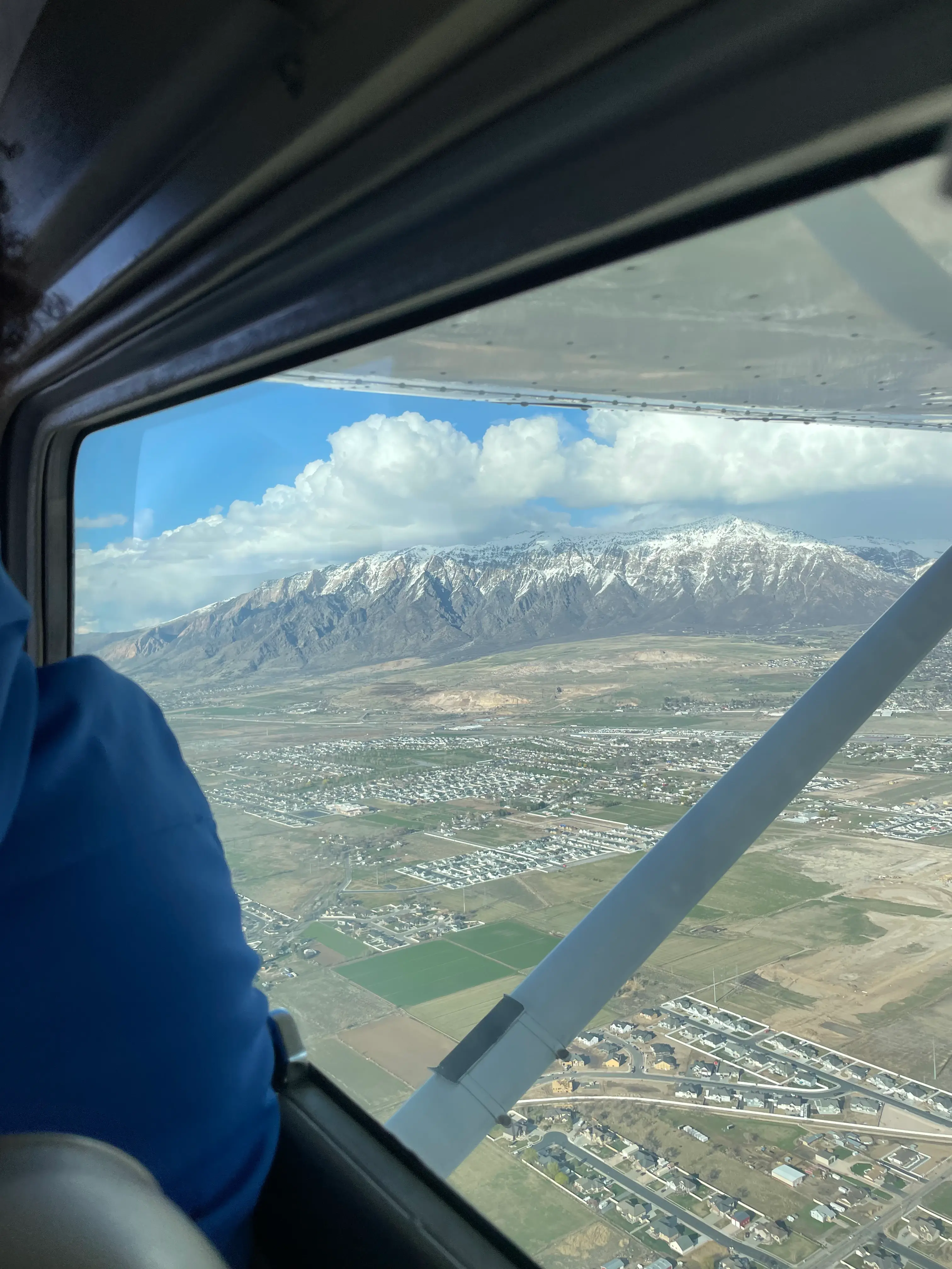 Above view of a city and a mountain range from an airplane window